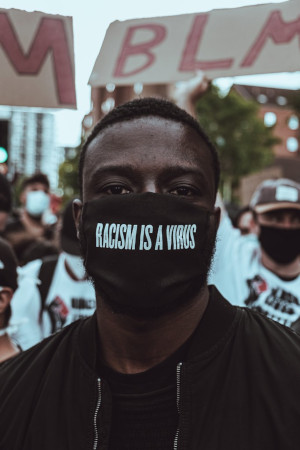 BLM protester with mask saying racism is a virus